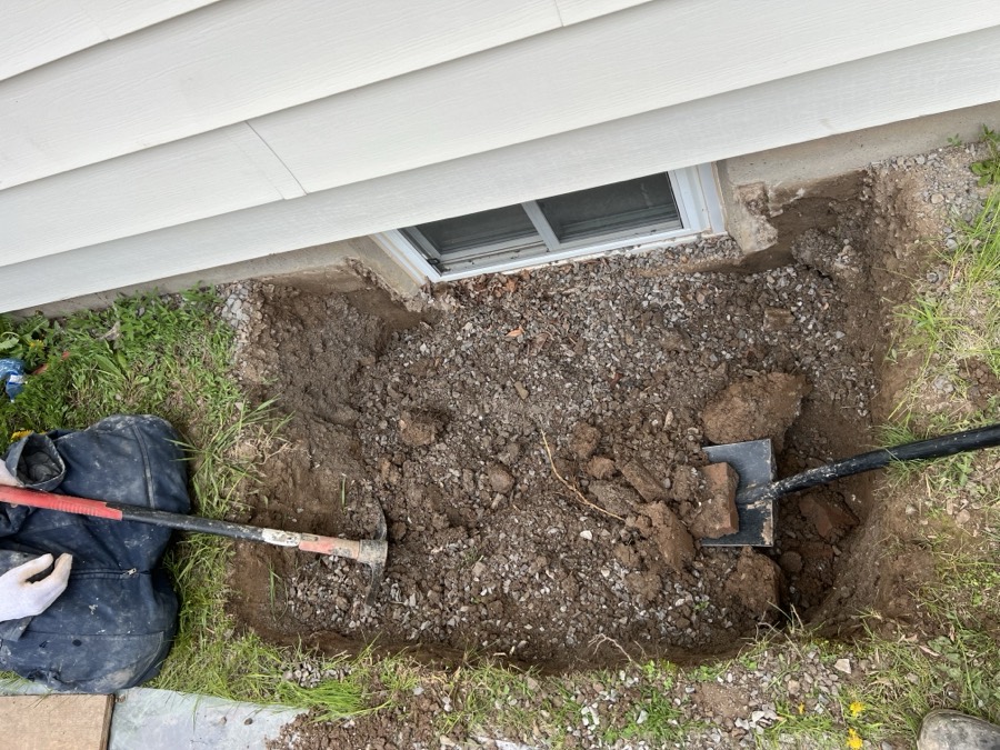 Hand dug excavation started at the basement window with pick and shovel