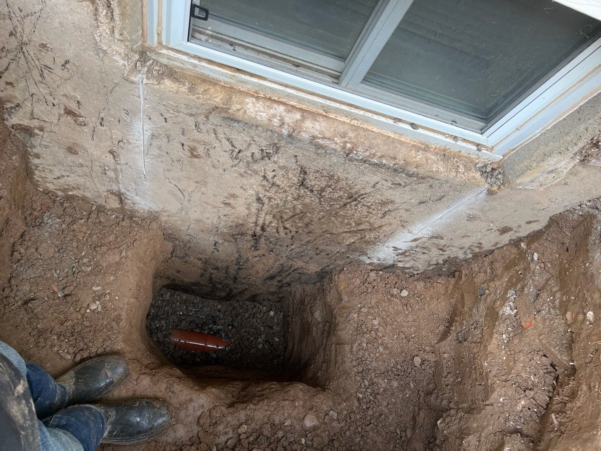 Window well excavation shaft dug down to the weeping tile